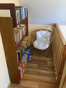 a stairway with a chair and books at DOMEK LETNISKOWY NA MAZURACH in Wydminy