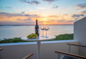 a table with a bottle of wine and two glasses at Brisas Beachfront Penthouses in Cancún
