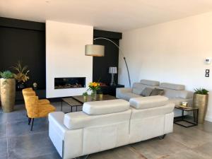 ein Wohnzimmer mit einem weißen Sofa und einem Tisch in der Unterkunft HÔTELYA - Lille Villeneuve d'Ascq in Villeneuve d'Ascq