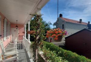 a porch of a pink house with flowers in a pot at Bijou Boutique Inn in Charleston