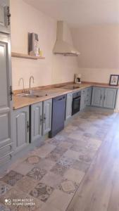 a kitchen with white cabinets and a tile floor at Gîte château d'Espalungue, piscine et SPA in Dognen