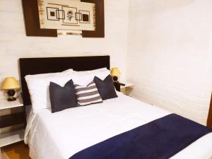 łóżko z czarno-białymi poduszkami w sypialni w obiekcie Canquerini Chalés w mieście Monte Verde