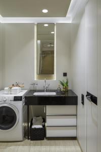 a bathroom with a sink and a washing machine at Sophisticated Condo in Nusle by Prague Days in Prague