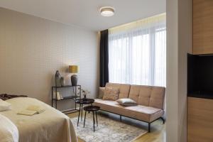 a bedroom with a bed and a couch and a window at Sophisticated Condo in Nusle by Prague Days in Prague