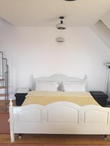 ein weißes Bett in einem Schlafzimmer mit einer weißen Wand in der Unterkunft Casa Flavia in Sancraiu de Mures