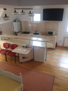 eine Küche mit einem Tisch und 2 roten Stühlen in der Unterkunft Casa Flavia in Sancraiu de Mures