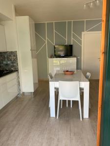 una sala da pranzo con tavolo bianco e sedie bianche di Appartamento Briccole al Faro a Cavallino-Treporti