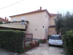 una macchina bianca parcheggiata di fronte a una casa di Apartment Zadar, Zadar County 8 a Smirić