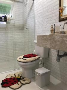 uma casa de banho com um WC, um chuveiro e um lavatório. em Sítio com belíssima paisagem para relaxar em Cobras