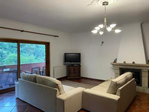 Sala de estar con 2 sofás y TV en Casa do Pedrógo en Geres