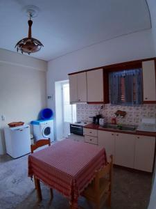 a kitchen with a table and a kitchen with white cabinets at TRADITIONAL HOUSE ALEPIS IN AREOPOLIS in Areopolis