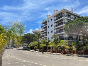 een gebouw aan de kant van een straat met palmbomen bij Falesia Beach Apartment in Albufeira