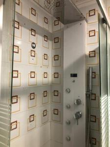 a bathroom with a shower with brown squares on the wall at Piccolo Attico in Lecce