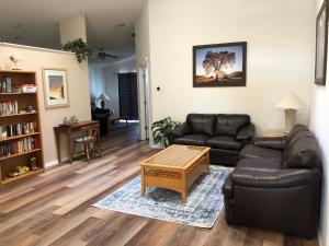 a living room with a leather couch and a coffee table at Pool Home 15 Minutes From Disney in Davenport