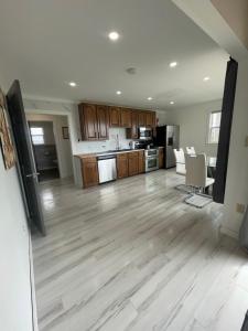 Amherst Cove Cottage # 5 في Borden-Carleton: مطبخ وغرفة معيشة فارغين وأرضيات خشبية