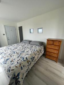 um quarto com uma cama e uma cómoda em madeira em Amherst Cove Cottage # 5 em Borden-Carleton