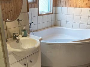 y baño con bañera blanca y lavamanos. en 8 person holiday home in Hadsund, en Odde