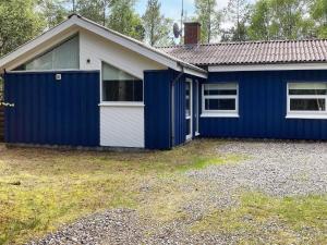 uma casa azul e branca com garagem em 8 person holiday home in Hadsund em Odde