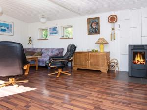 een woonkamer met een bank en een open haard bij 8 person holiday home in rsted in Ørsted