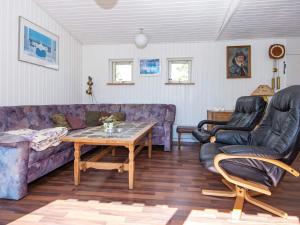 een woonkamer met een paarse bank en 2 stoelen bij 8 person holiday home in rsted in Ørsted