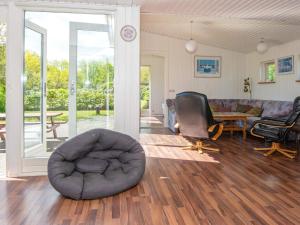 een woonkamer met een stoel en een bank bij 8 person holiday home in rsted in Ørsted