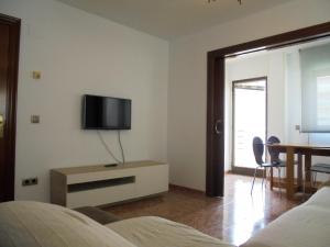 1 dormitorio con TV en la pared y mesa en Maestrat, en Peñíscola