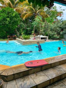 a group of people swimming in a swimming pool at Jardim Secreto Guest House in Búzios