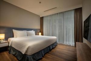 - une chambre avec un grand lit et une grande fenêtre dans l'établissement Flamingos Cat Ba Resort luxury, à Hai Phong
