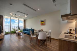 a living room with a table and a blue couch at Flamingos Cat Ba Resort luxury in Hai Phong