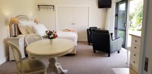 a hotel room with a bed and a table and chairs at Belle Maison French Country Stay in New Plymouth