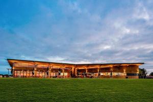 a large building with a green field in front of it at Pinnacle of Comfort on the Bellarine, Curlewis. in Drysdale