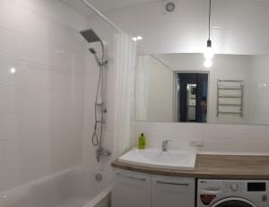 W łazience znajduje się umywalka, wanna i lustro. w obiekcie Чудова квартира в центрі міста w mieście Rivne