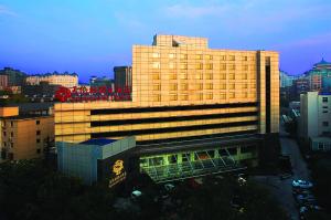 um grande edifício amarelo no meio de uma cidade em Sunworld Hotel Wangfujing em Pequim