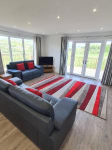 a living room with a couch and a large rug at Valley View Cottage in Rothbury