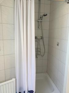 a shower with a white shower curtain in a bathroom at Horizont in Grube