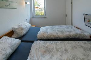 1 dormitorio con 2 camas y ventana en Meermaid, en Dornumersiel