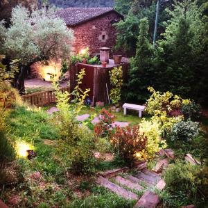 ogród z ławką na środku dziedzińca w obiekcie Les Casetes del Congost Vilatge Resort Barcelona w mieście Tagamanent