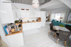 a kitchen with white cabinets and a table and chairs at Kalvåg Holidayapartment in Kalvåg +19 photos