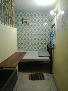 um pequeno quarto com um banco e uma parede em Bubble Beds em Calcutá