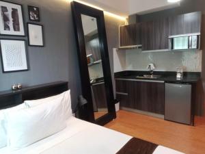 um quarto com uma cama, uma pia e um espelho em Studio Unit at The Beacon Makati em Manilla