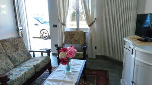 a living room with a couch and a vase of flowers on a table at House in The Calm Nature of Prosecco Valley in Revine Lago