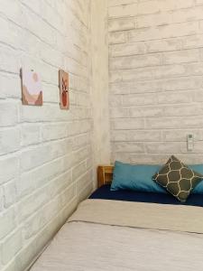 1 dormitorio con cama y pared de ladrillo en KALINDA HOMEY en Karimunjawa