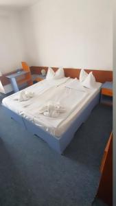 Una cama blanca con sábanas blancas y almohadas. en Hotel Banat, en Olimp