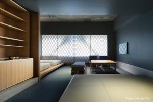 a room with a bed and a table and a window at KUMU Kanazawa by THE SHARE HOTELS in Kanazawa