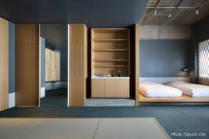 KUMU Kanazawa by THE SHARE HOTELS في كانازاوا: غرفة نوم مع سرير بطابقين ومرآة