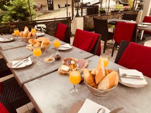 a table with baskets of bread and glasses of orange juice at Hôtel U Passa Tempu in Corte