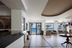 a kitchen and living room with a view of the ocean at Golden Bay Boutique Hotel & Bungalows in Kokkíni Khánion