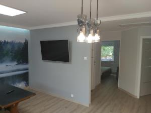 uma sala de estar com uma televisão de ecrã plano na parede em Apartment for you 1 Królewiecka 40B em Mrągowo