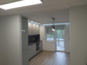 uma cozinha vazia com armários brancos e uma janela em Apartment for you 1 Królewiecka 40B em Mrągowo