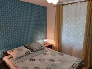 um quarto com uma cama com uma parede azul em Apartment for you 1 Królewiecka 40B em Mrągowo